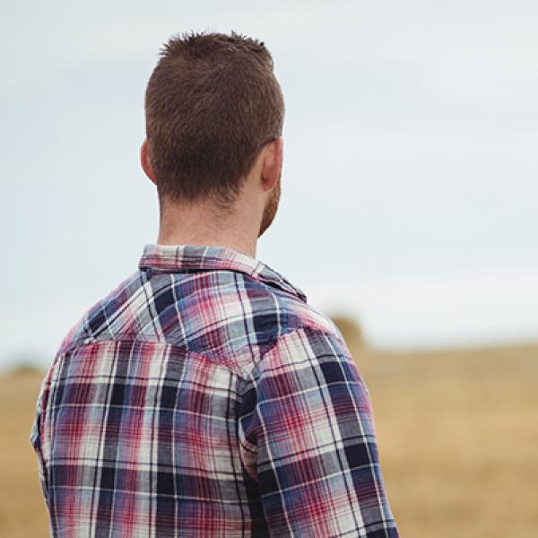 View from behind of a man looking at a field