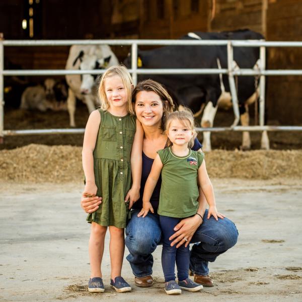 Mother and daughters pose with cows in the background
