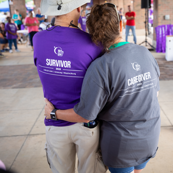view of the back of two people hugging who are wearing Relay for Life tshirts