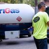 AmeriGas representative in a high-vis t-shirt shaking hands with a customer in front of her home with an AmeriGas propane truck in the background