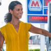 A woman smiling while pumping gas into her car at a Marathon gas station