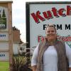 Portrait of Macomb County Farm Bureau president Amanda Kutchey smiling in front of a sign reading "KUTCHEY'S FARM MARKET."